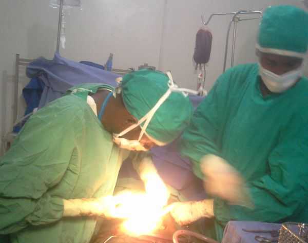 Picture of surgeons operating on patient with ruptured uterus
